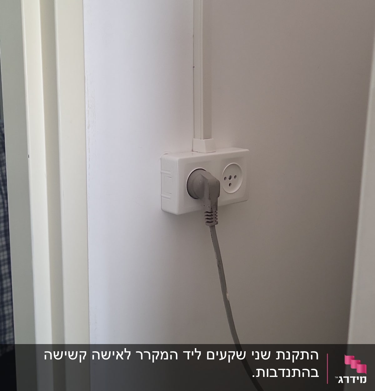 שקע חשמל עם תקע מחובר לקיר לבן